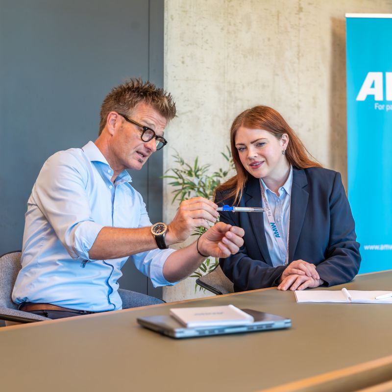 Mitarbeiterin von AMW im Gespräch mit Geschäftspartner