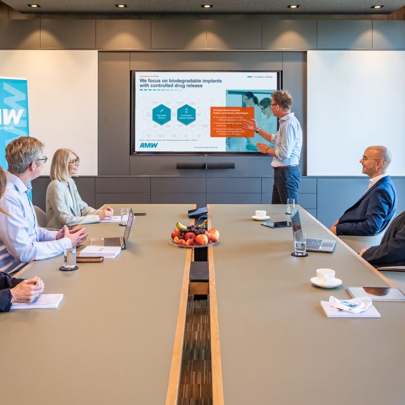 Employees and staff from distribution partners talking in a meeting room at AMW