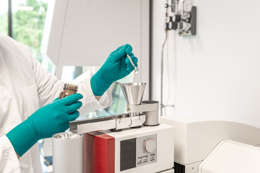 Labormitarbeiter füllt Flüssigkeit mit Pipette in einen Trichter