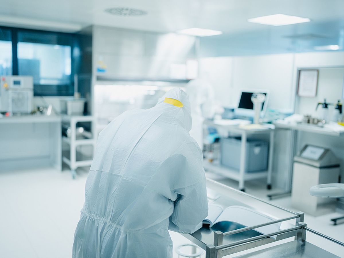 Labormitarbeiter trägt Ergebnisse in Prüfbuch ein