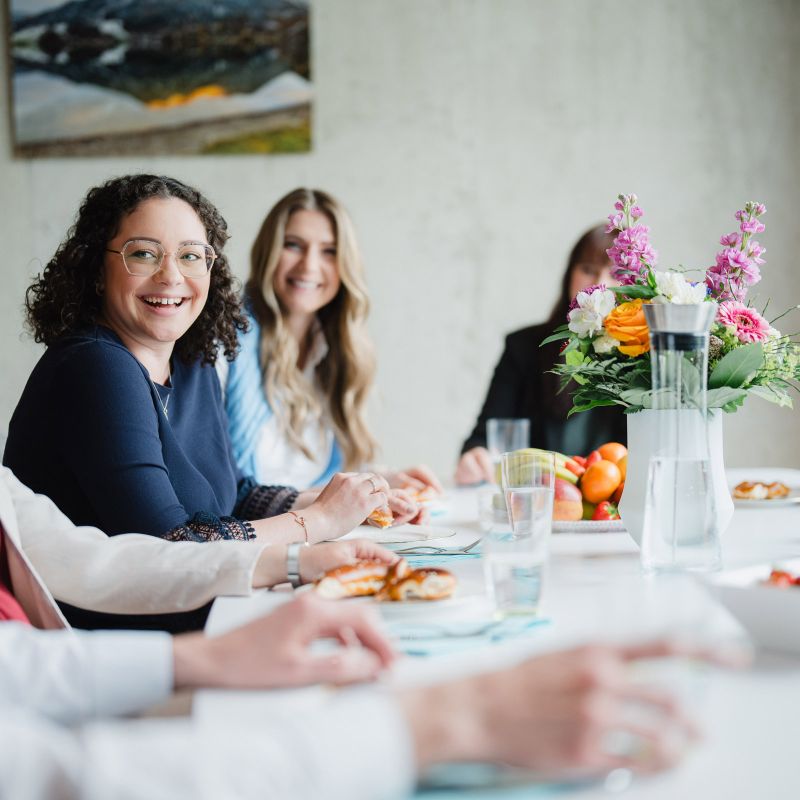 Colleagues of AMW sitting together at the table in high spirits